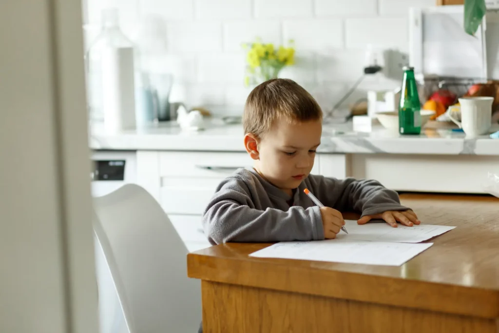Young boy concentrating on his homework at a kitchen table