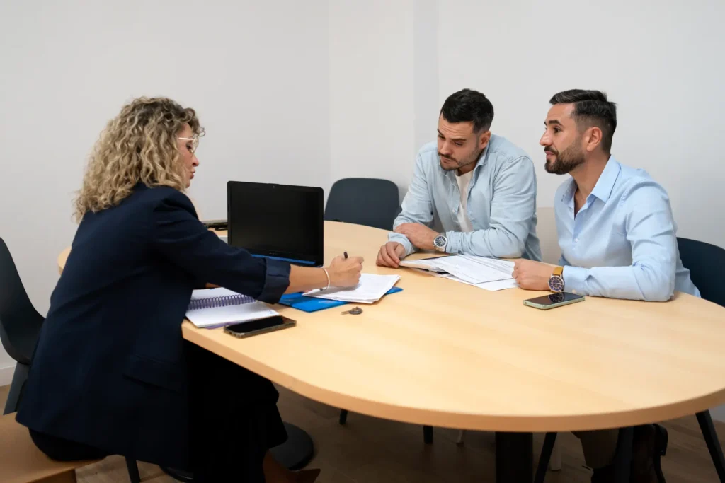 Family mediator sitting with two people around a table discussing a financial settlement